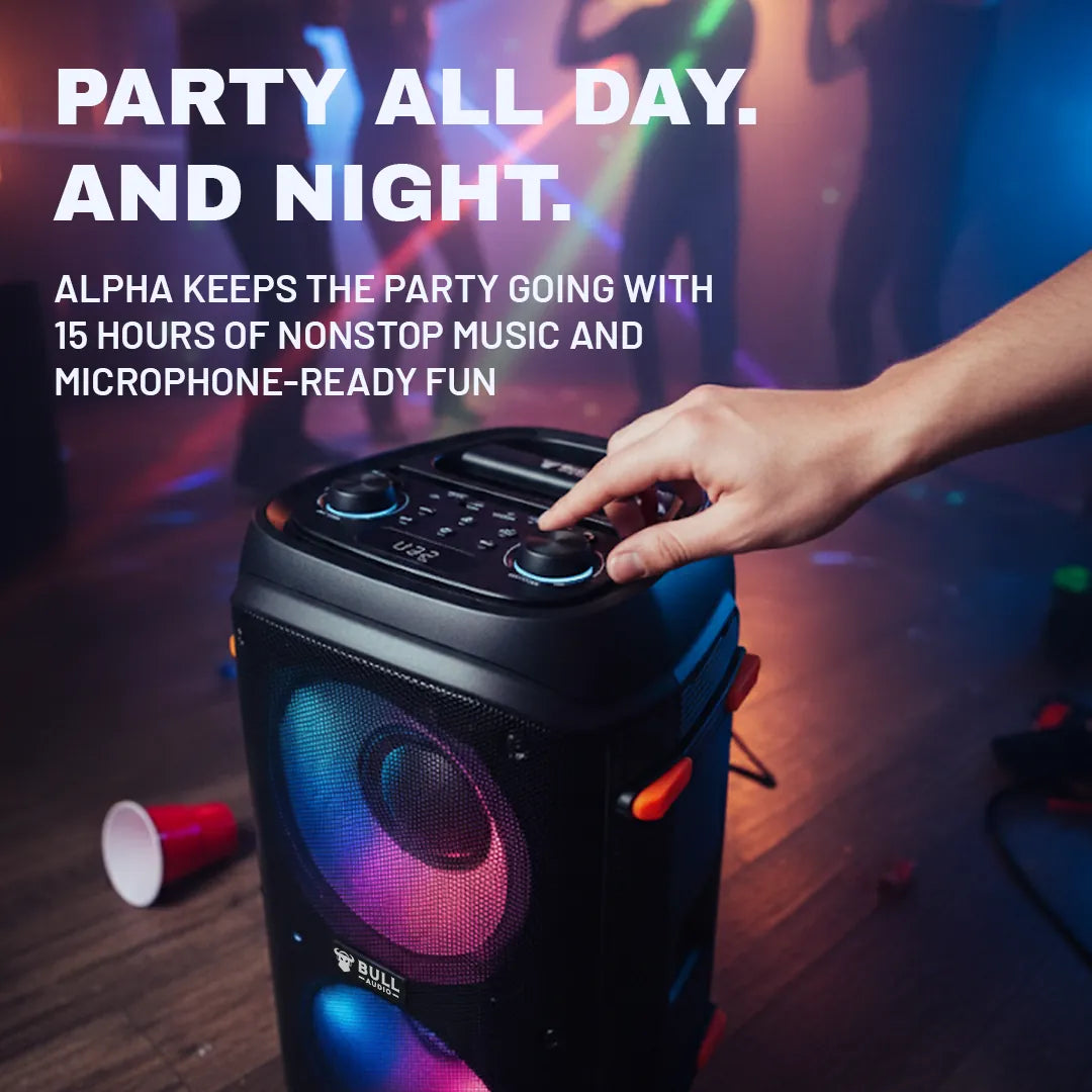 Bull Audio Alpha speaker with colorful lights and hand adjusting top controls at a party.